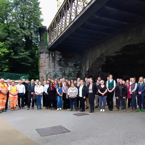 Group of people stood under a bridge
