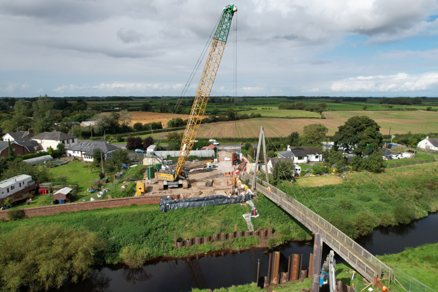 Drone shot of crane lifting piles into place 