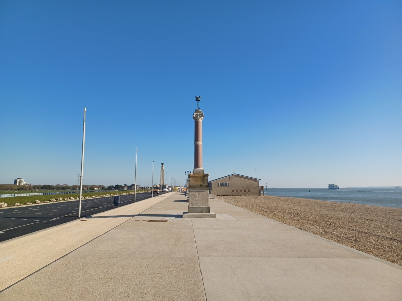 Promenade with monument in the background. Blue skies