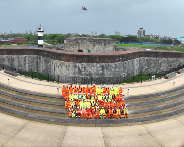 People in highvis sat on the steps of the Southsea Coastal Scheme.