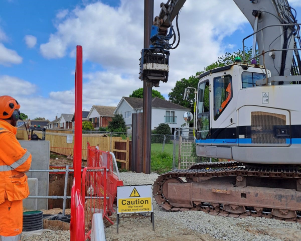 Piling machine inserting a pile into the ground at a construction site