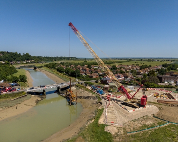lifting crane over a river, lifting sheet piles