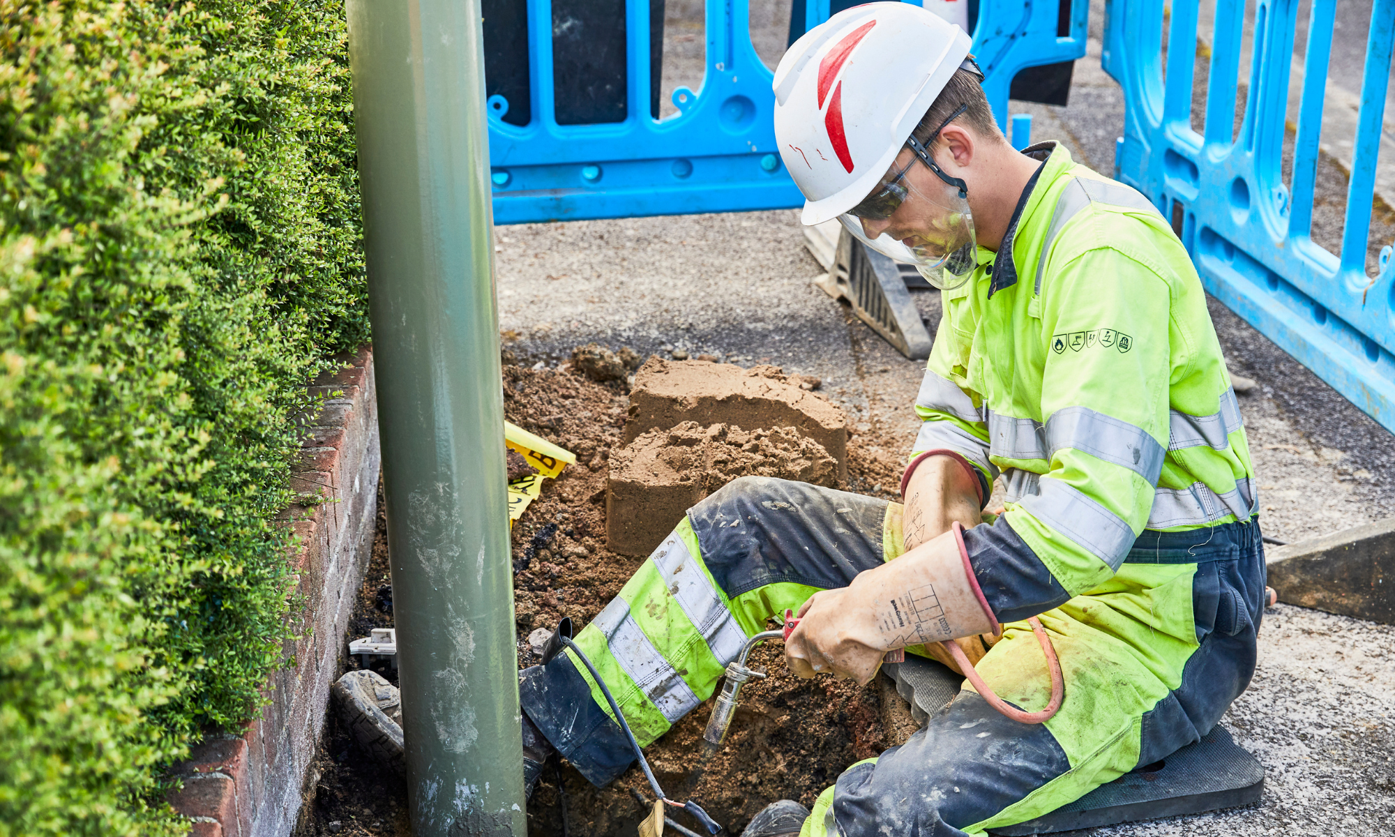 Man in yellow PPE connecting a street power source