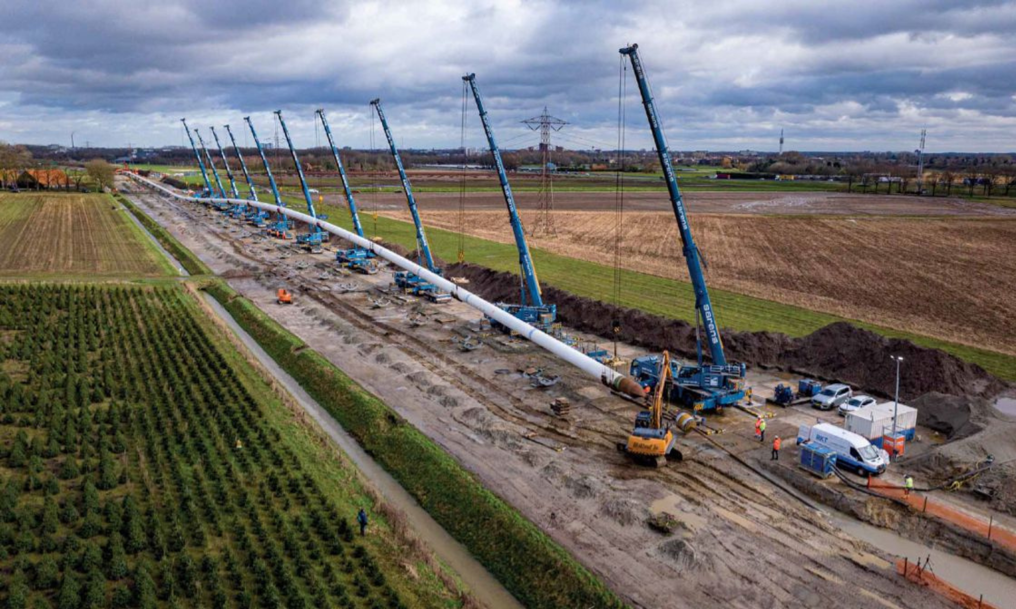 A HDD Arc, showing pipe held by 7 cranes