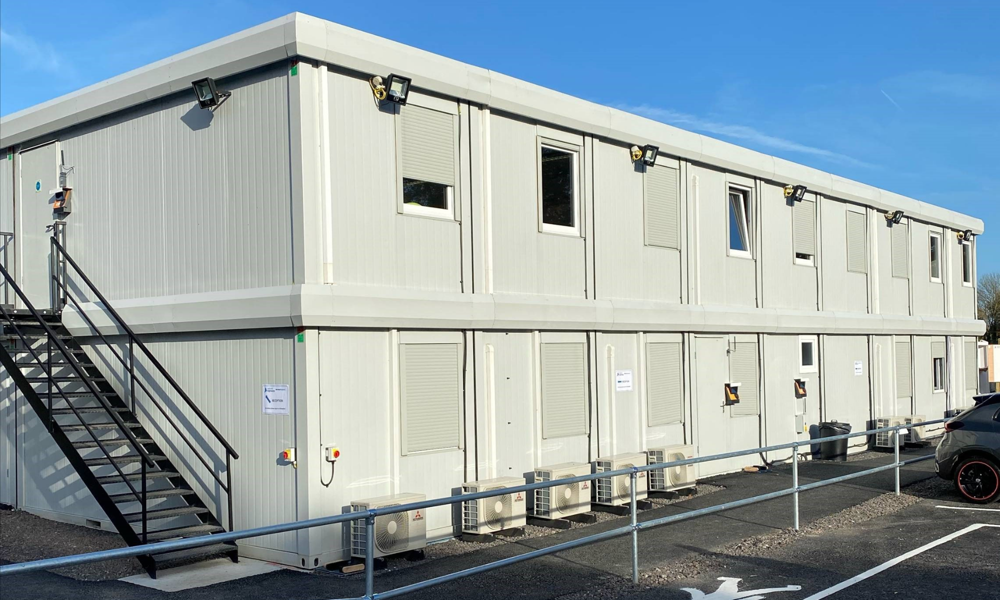 Photo showing accommodation units staked two high with a black external staircase