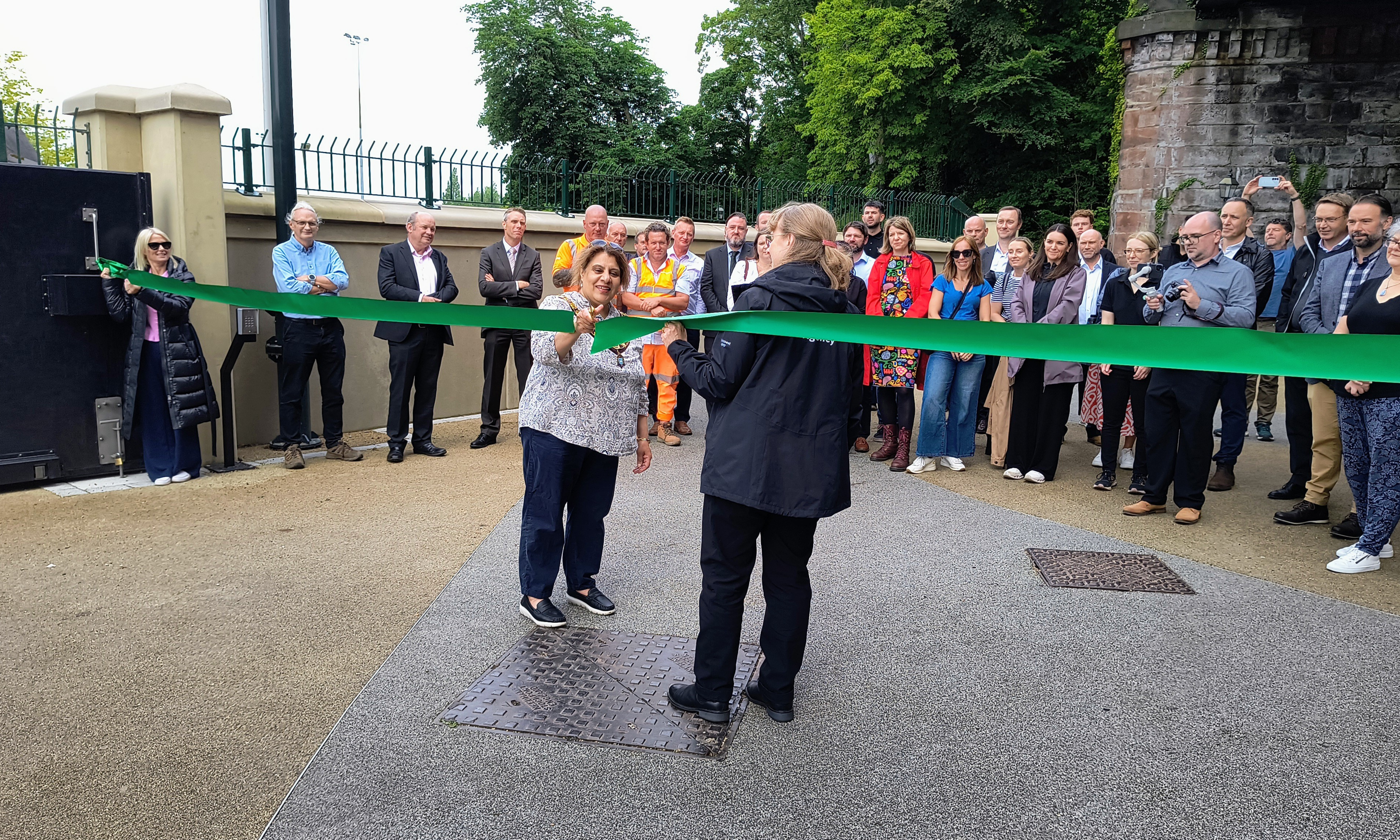 Women cutting a green ribbon